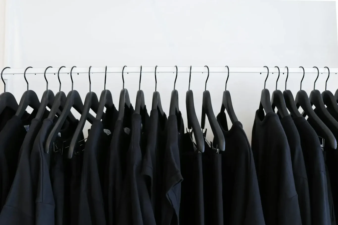 Ropa color oscura camisetas de color negro colgadas en perchero